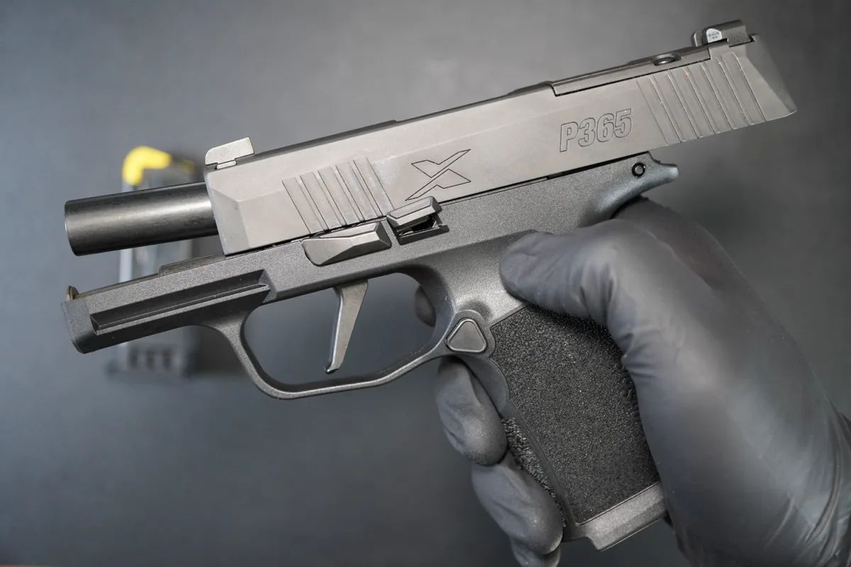 SIG Sauer P365X held in a gloved hand, ready for cleaning